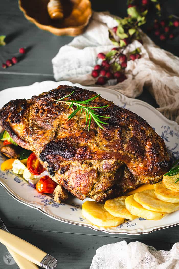 pork roast on a serving platter with roasted vegetables