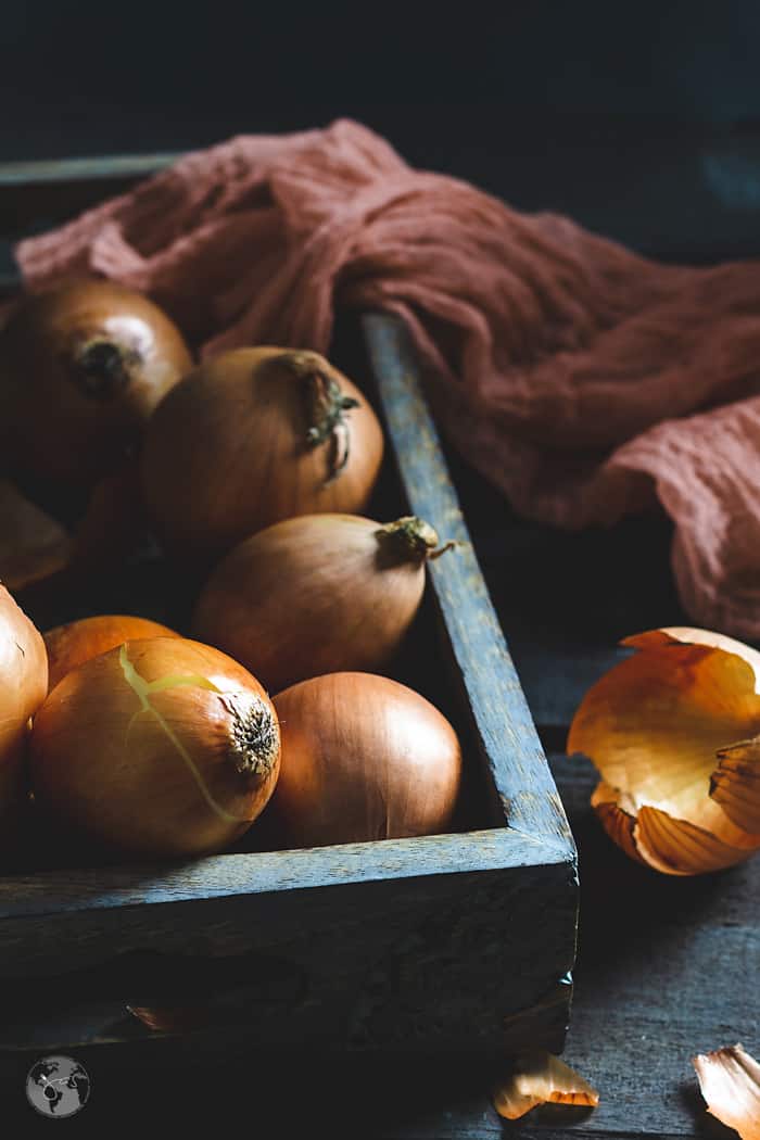 A wooden tray with onions.