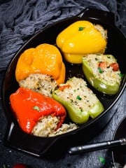 Stuffed peppers in a black baking dish.