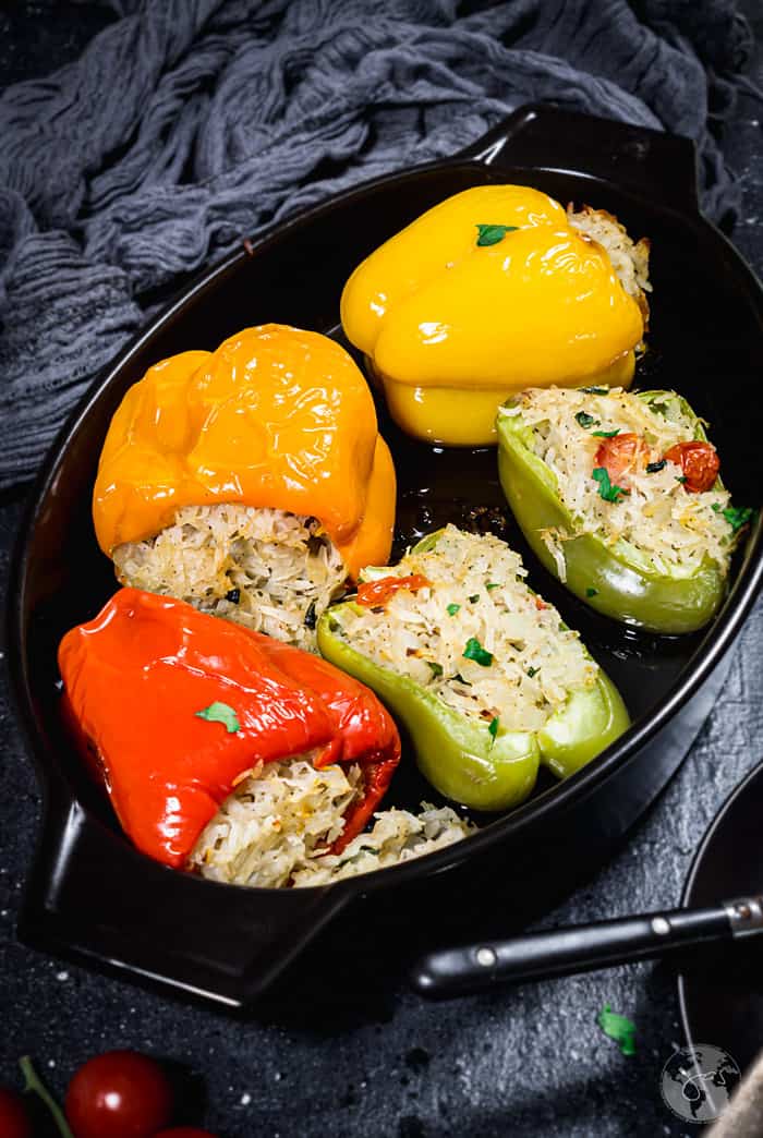 Stuffed peppers in a black baking dish.