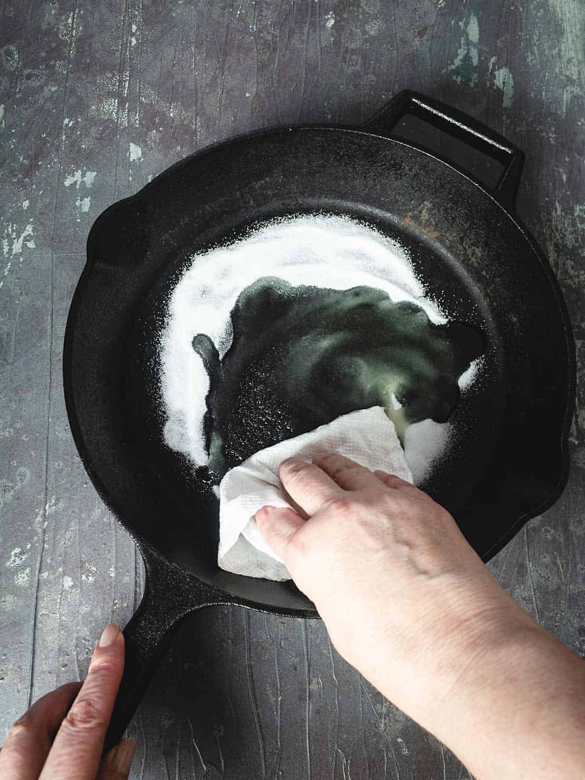 Rubbing salt onto the pan to remove rust.