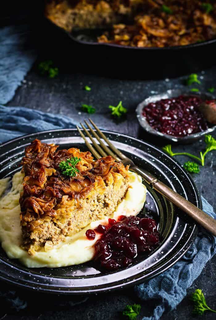 A slice of cabbage pudding over mashed potatoes.