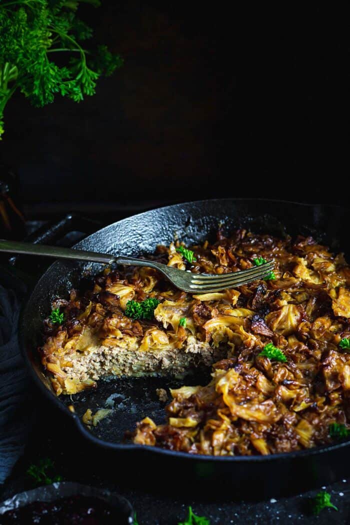 A skillet with cabbage casserole sliced in.