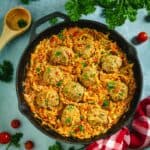 Cast-iron skillet with unstuffed cabbage rolls on a blue background.