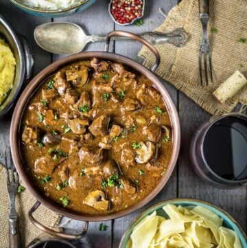 a flat lay of Instant pot beef stew on a gray wood table with bowls of pasta and potato mash