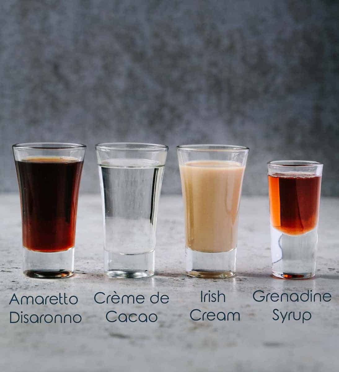 Four small glasses with different alcohol ingredients for jellyfish shot