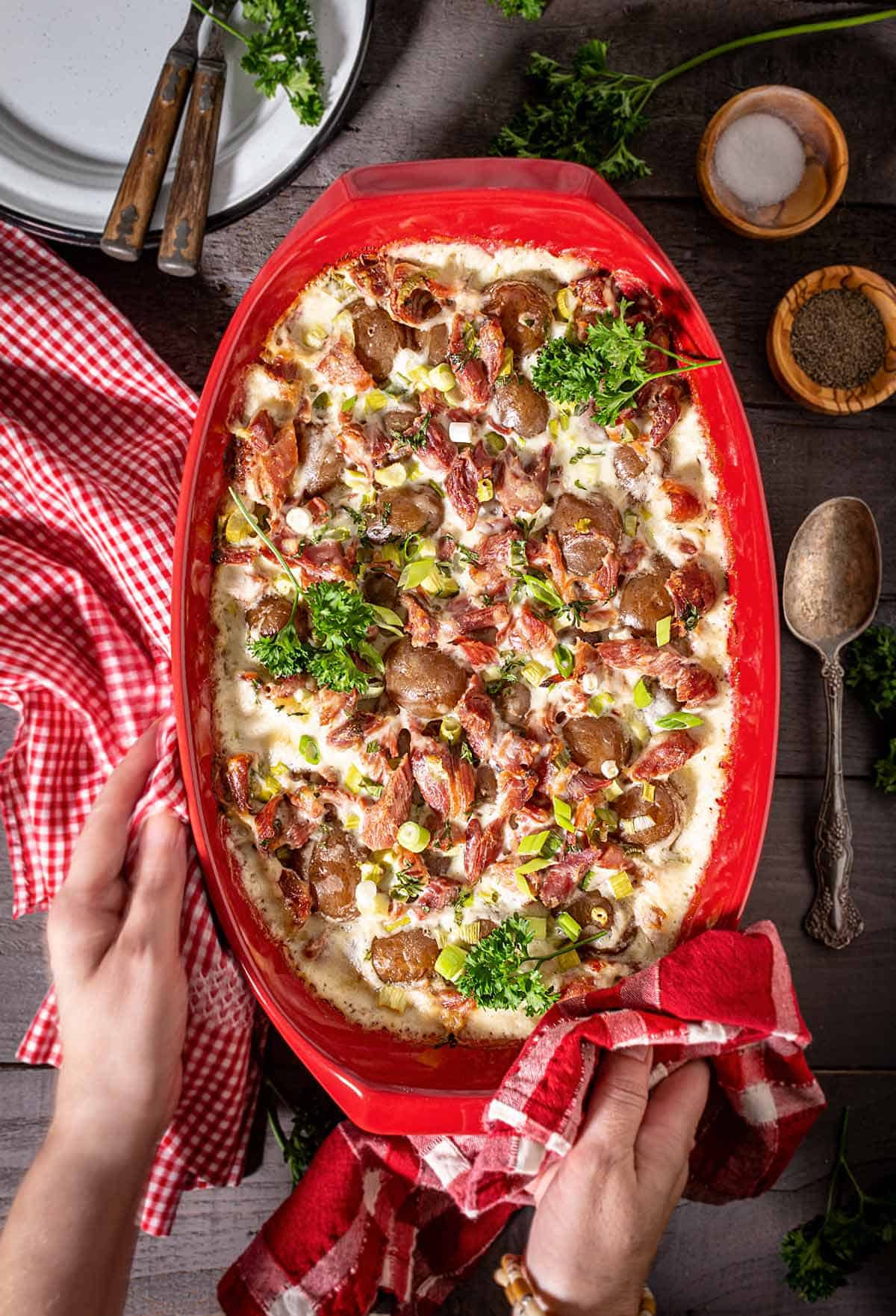 A person serving the dish with potato casserole