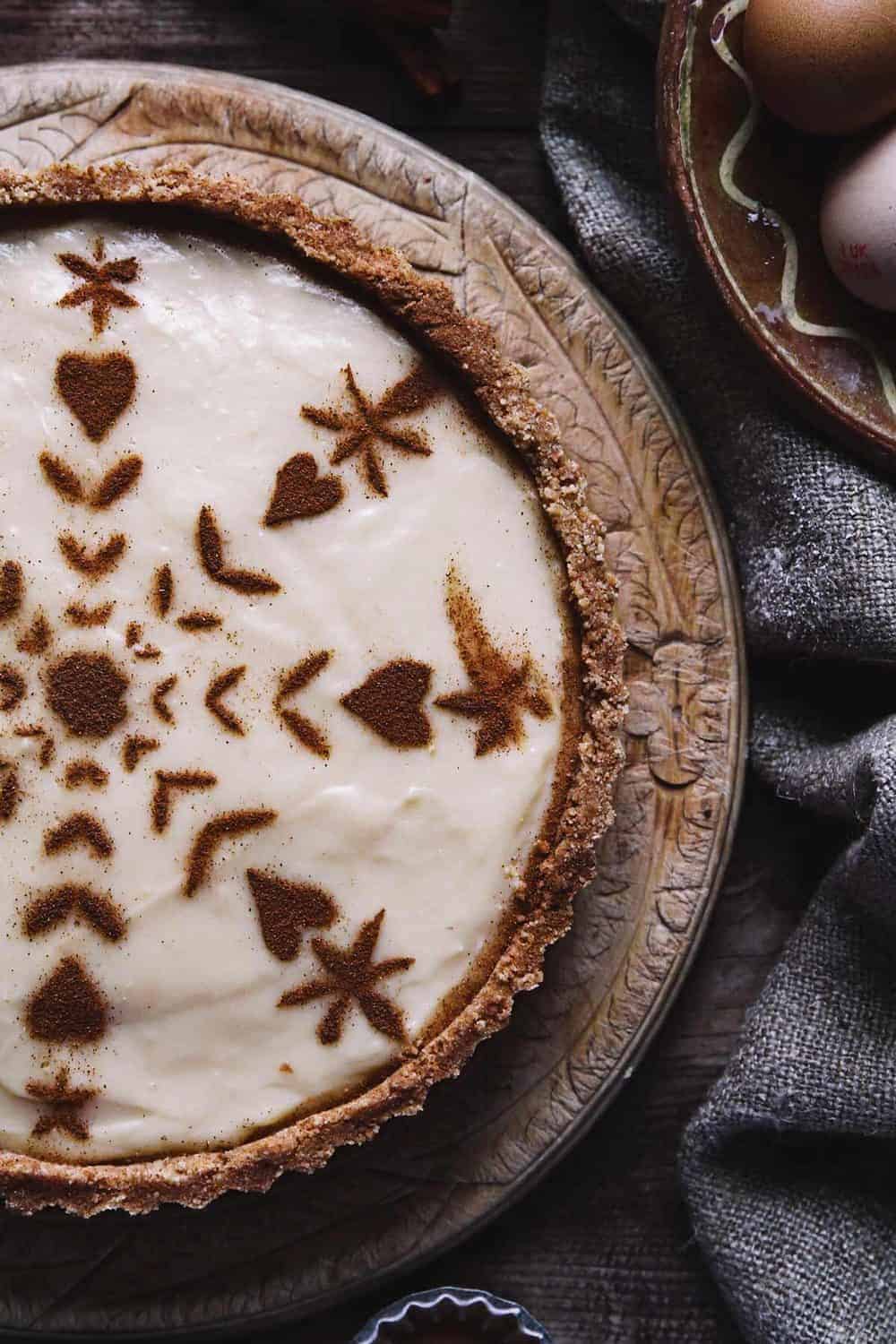 A close up of classic creamy African tart with cinnamon pattern on the top.