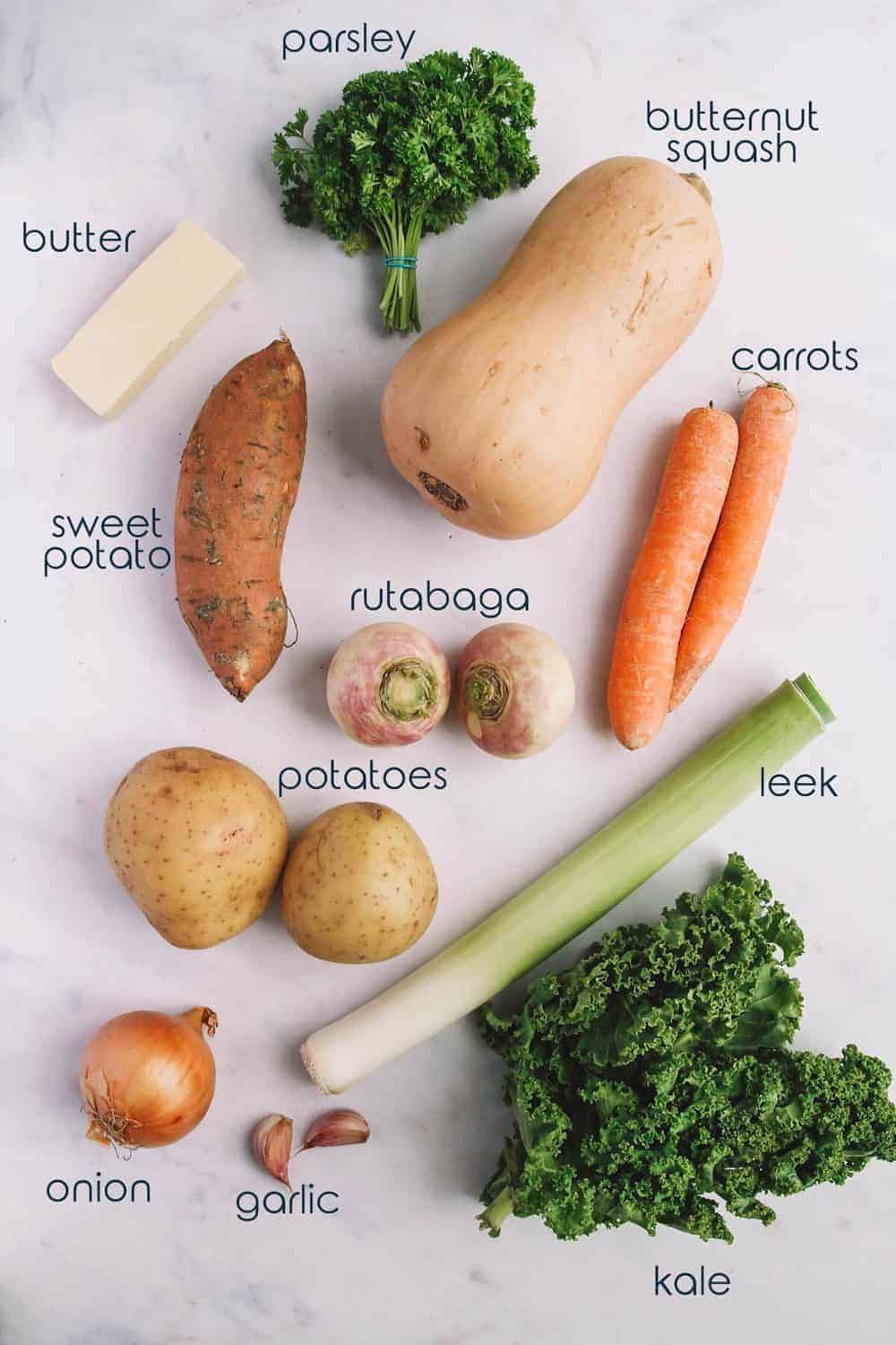 Ingredients for Dutch style creamy stew recipe on the table, including butternut squash, potatoes, and leek.