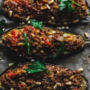 Three eggplant halves stuffed with minced lamb meat.