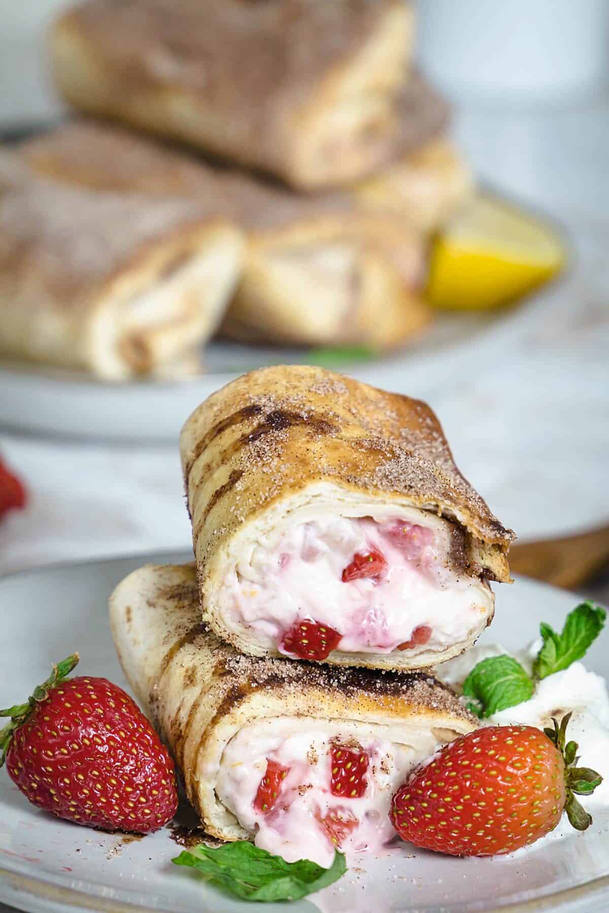 Fried cheesecake rollups halved on top of each other.