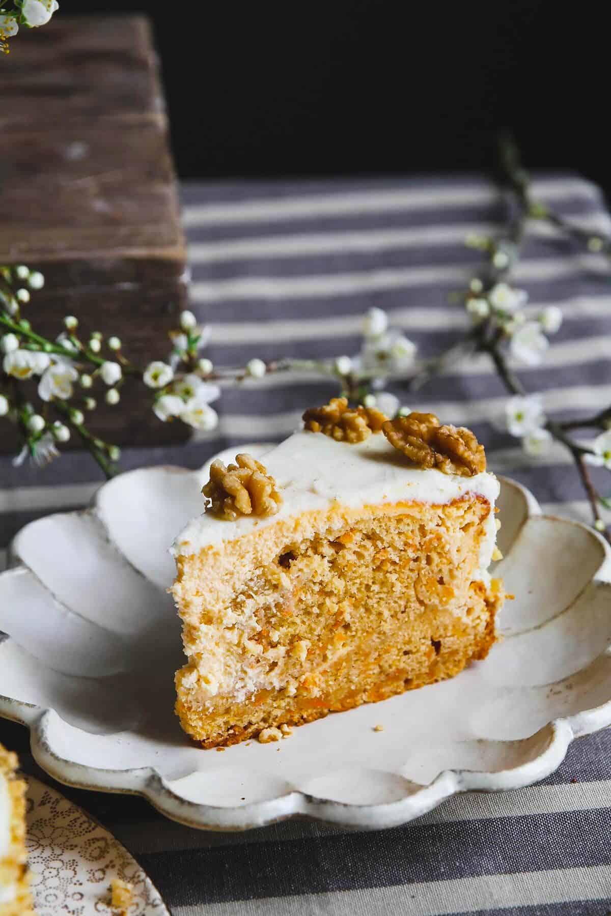 A close up of a carrot cake cheesecake slice on a white plate.