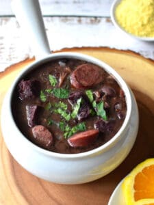 Black bean and sausage stew in a white serving bowl.
