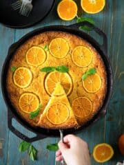 A peson taking out a slice of Greek orange cake with fillo dough.