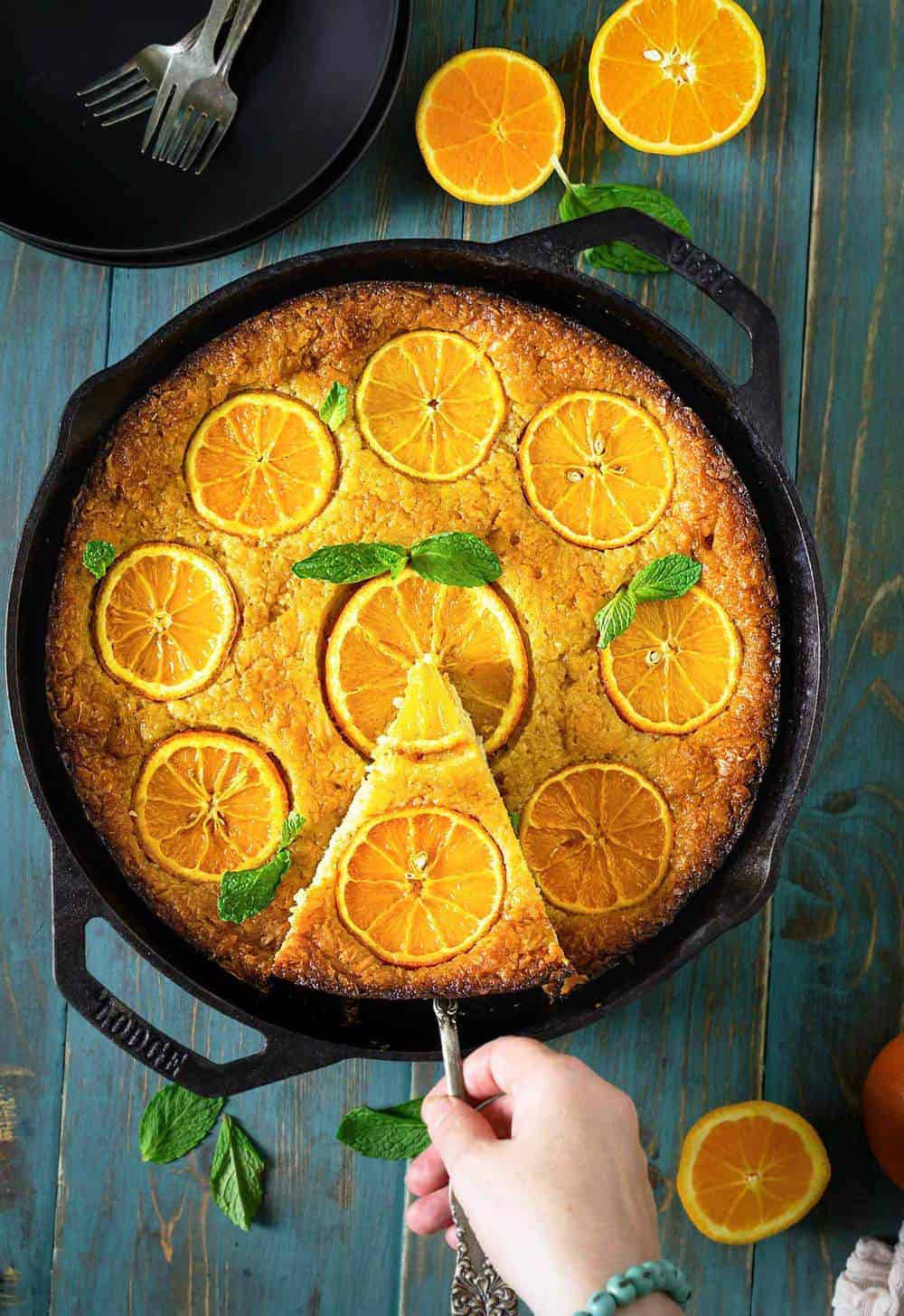 A peson taking out a slice of Greek orange cake with fillo dough.