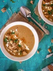 A bowl with browned flour soup, croutons, parsley, and sour cream.