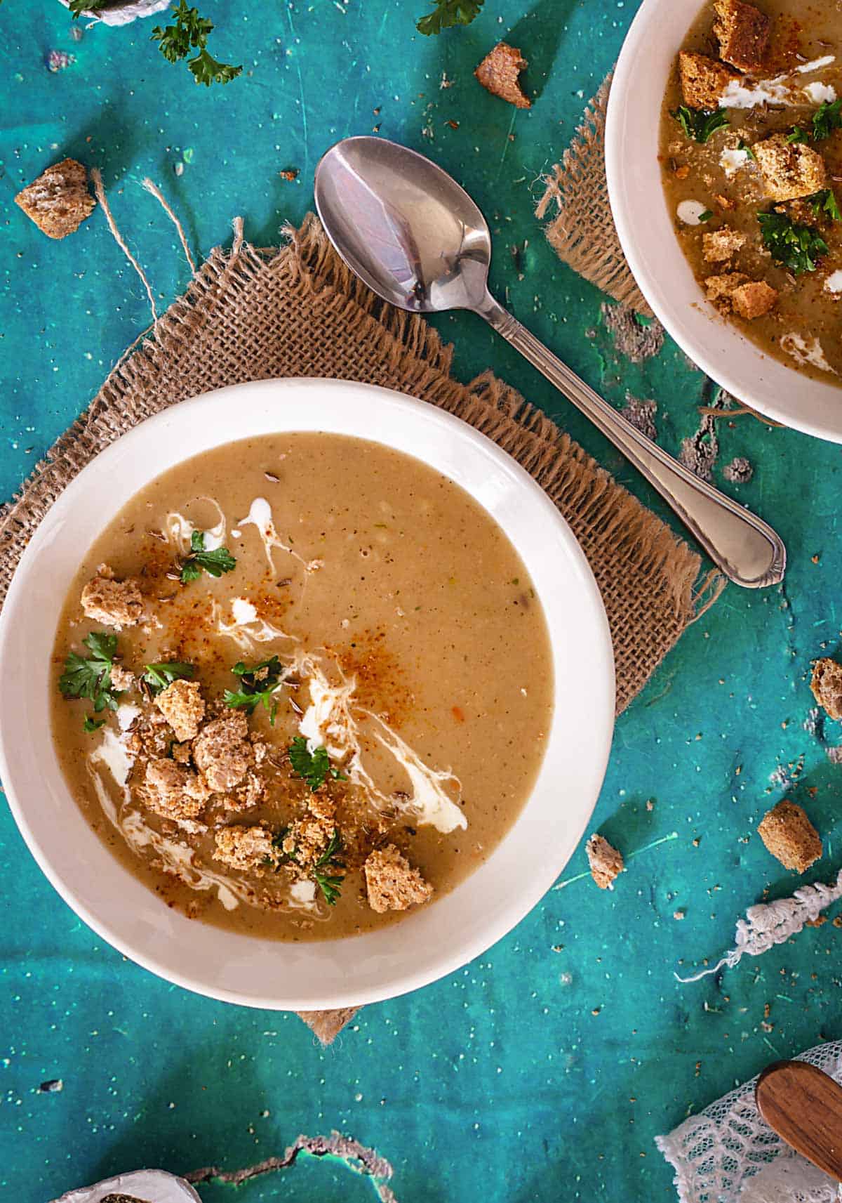 A bowl with browned flour soup, croutons, parsley, and sour cream.