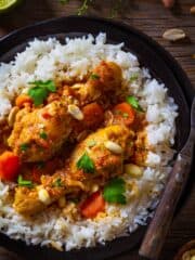 A close up shot of Djerma stew with chicken and peanuts over rice.