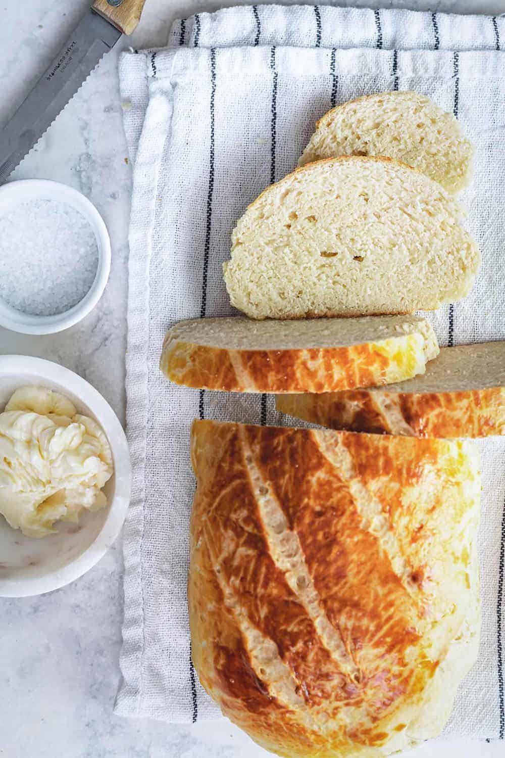 Sliced no soda bread on a kitchen towel with butter and salt.