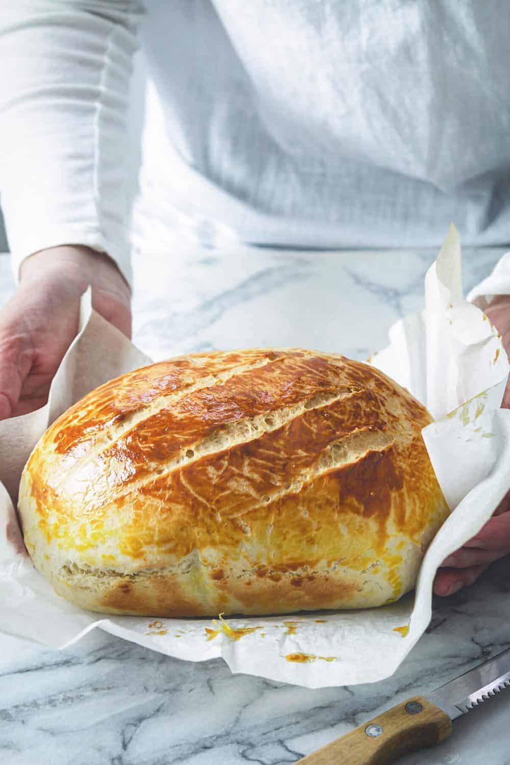 A person placing fresh bread with no yeast on a table.