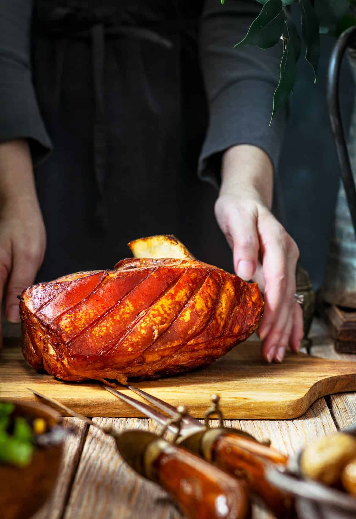 A person placing the pork roast on a table.