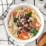 A close up of chicken barley krupnik soup in a bowl.