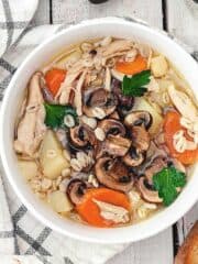 A close up of chicken barley krupnik soup in a bowl.