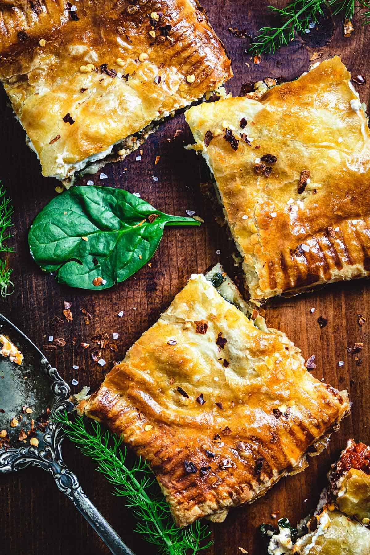 Three slices of Italian sausage slab pie on a cutting board.