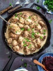 An overhead photo of cast-iron skillet with Swedish meatballs in a creamy gravy.