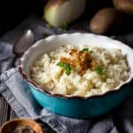 Vegan mashed potatoes in a bowl with caramelized onions - featured square image.