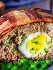 Close up of a sliced meatloaf with hard-boiled egg inside.