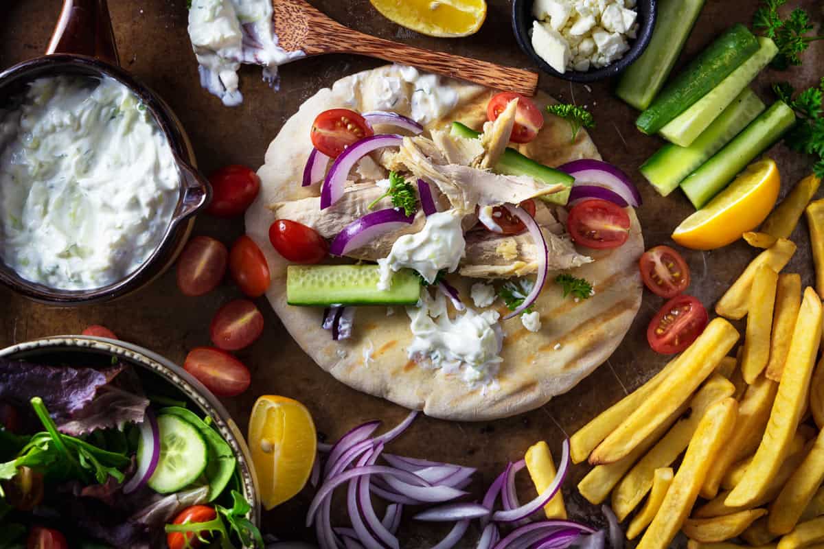 Assembling gyro ingredients on a pita bread.