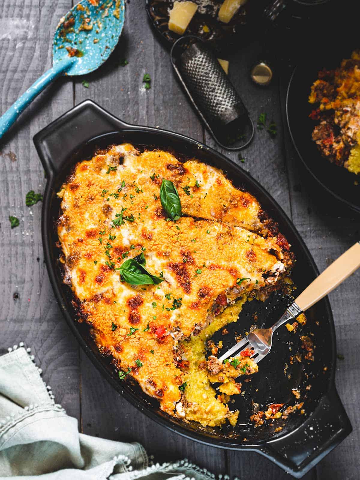 Polenta beef casserole with vegetables in an oval baking dish on a table.