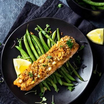 Baked salmon with mayonnaise topping and crouton-parmesan crust plated on green beans.