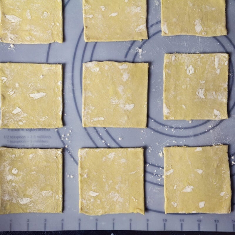 Puff pastry sheet cut into 9 small squares.