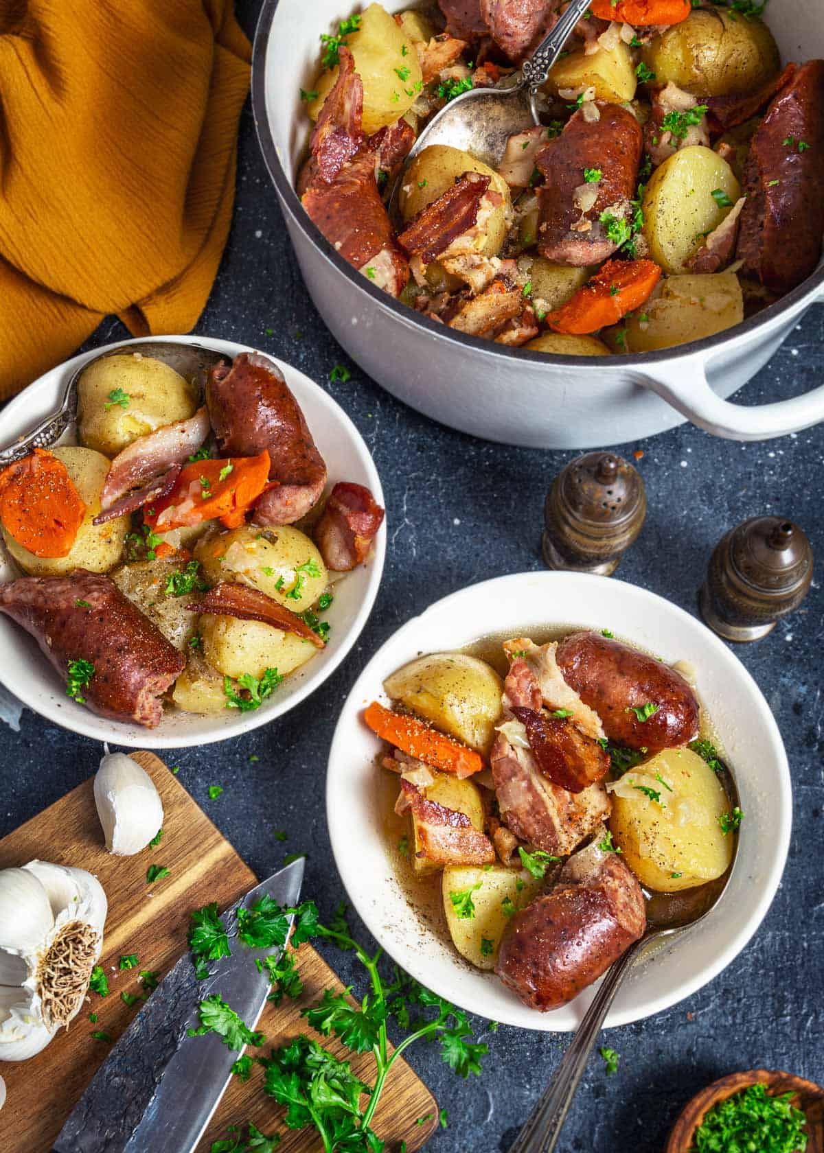 Irish potato sausage stew in a Dutch oven and two bowls. 