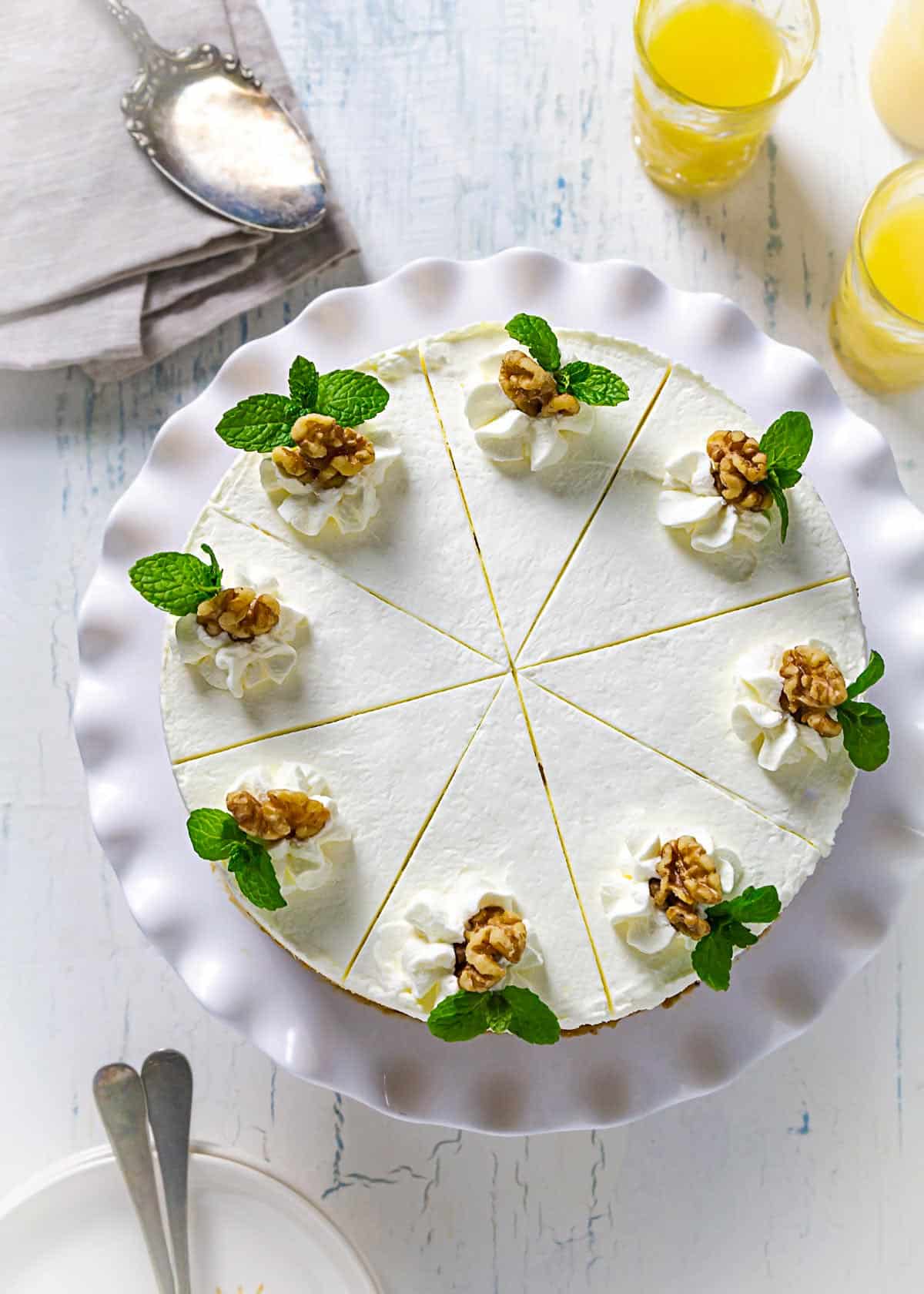 An overhead view of decorated sand cake with cool whip, walnuts, and mint leaves as garnish.