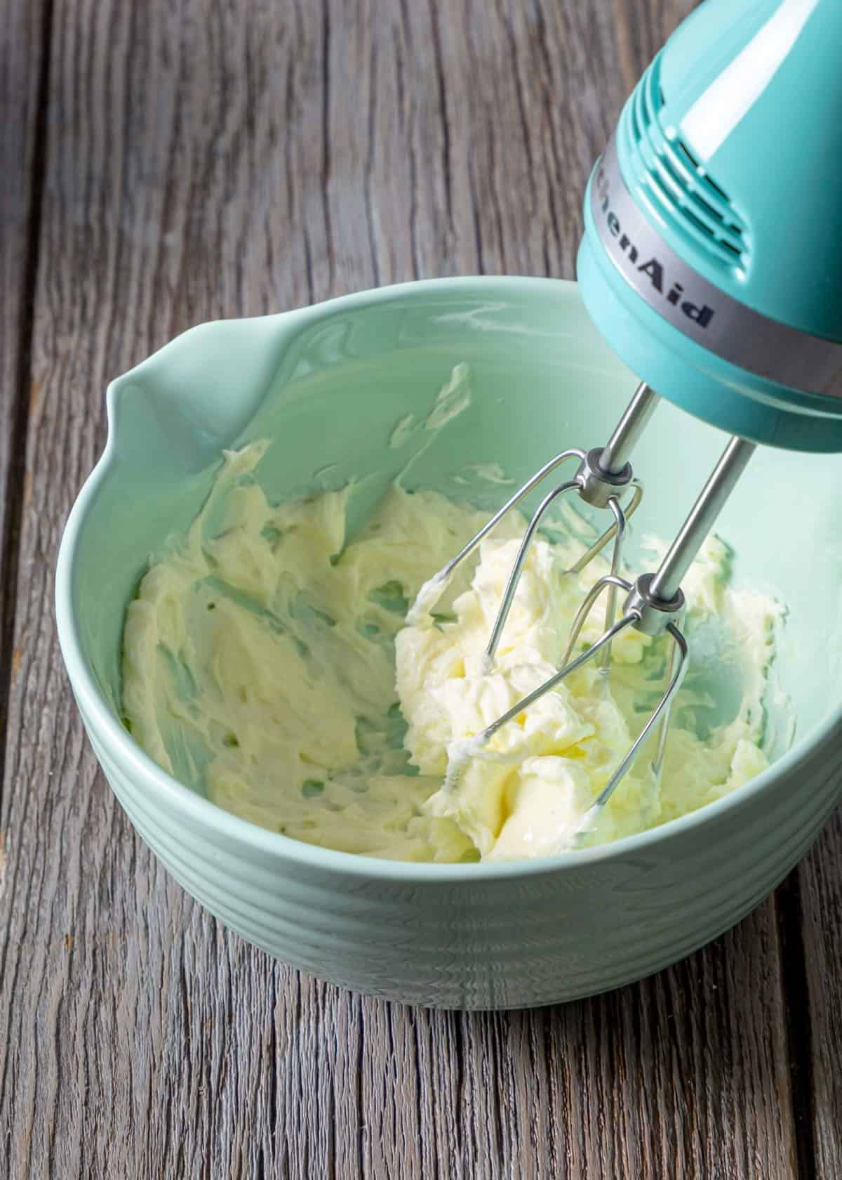 Beating butter in a bowl with a mixer. 