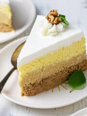 A big slice of sand cake on a plate with a dessert spoon.