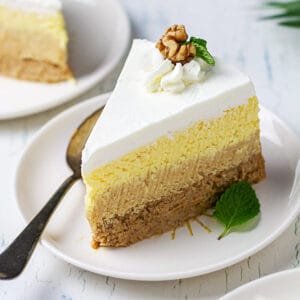 A big slice of sand cake on a plate with a dessert spoon.