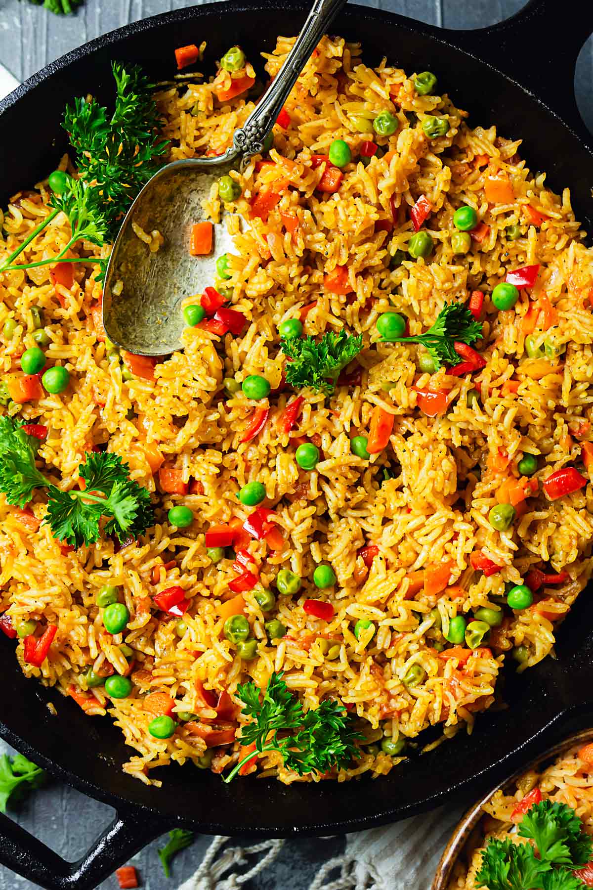 A close up of vegetable rice sprinkled with parsley.