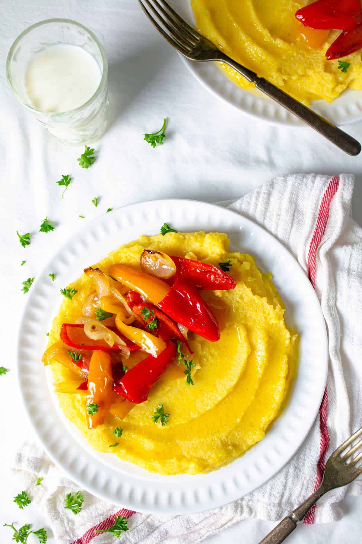 Servings of soft polenta with sautéed onions and peppers topping. 