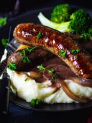 British pork sausage with onion gravy and mashed potatoes - featured square image.