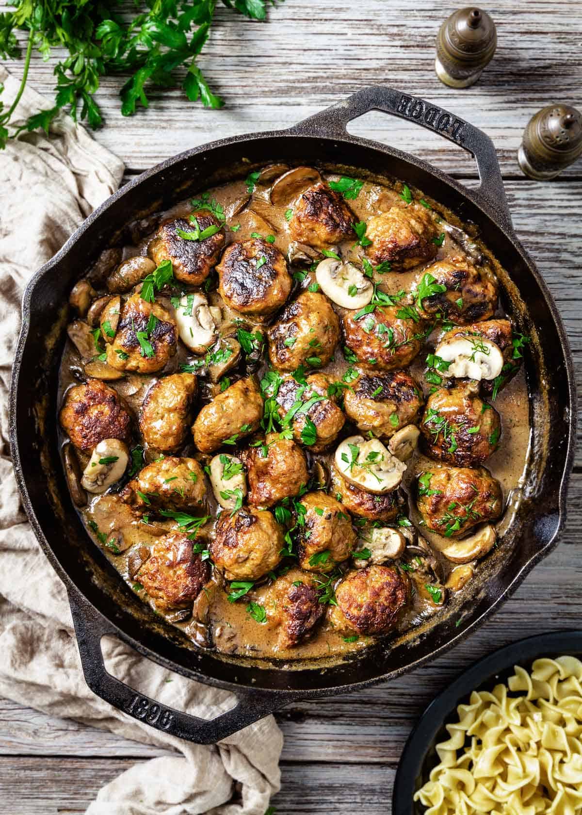 An overhead shot of pork meatballs stroganoff in a skillet.