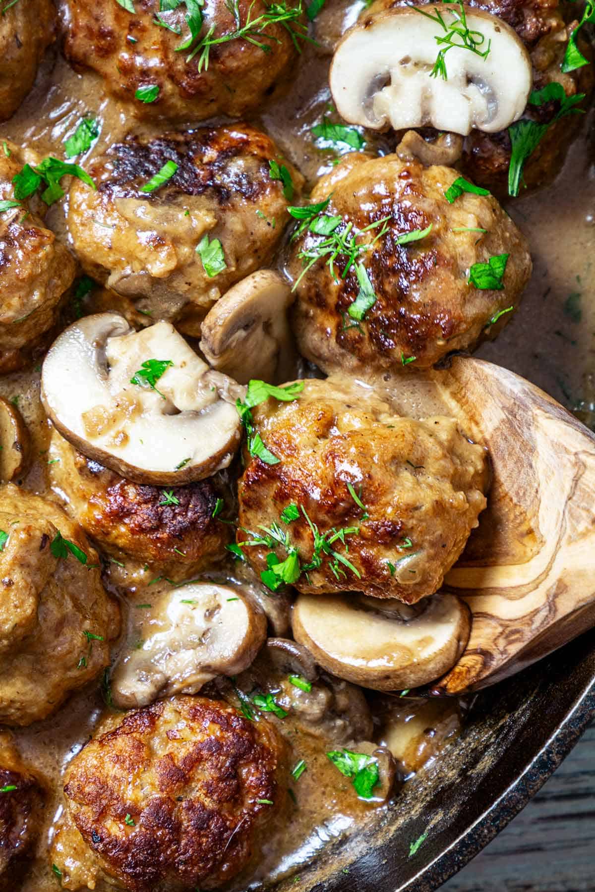 A close up of creamy mushroom sauce with pork meatballs.