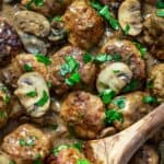 Featured square photo of pork meatballs with creamy mushroom sauce and a wooden spoon.