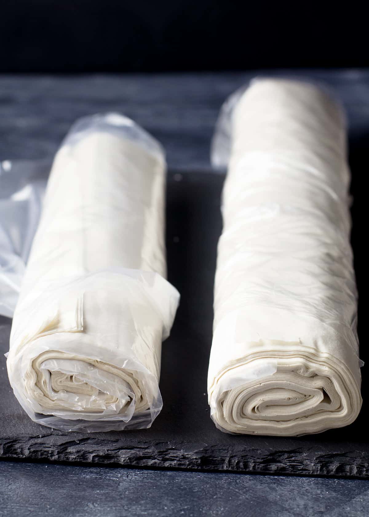 Two rolls of fresh fillo pastry sheets showing the layers.
