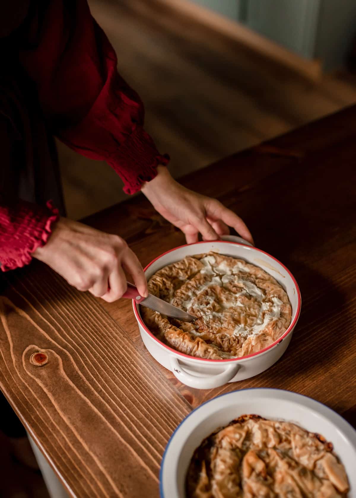 Cutting the baked fillo pastry dish.