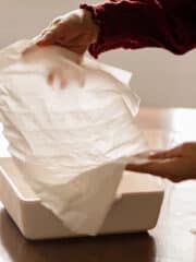 A sheet of filo dough being placed into a backing pan.