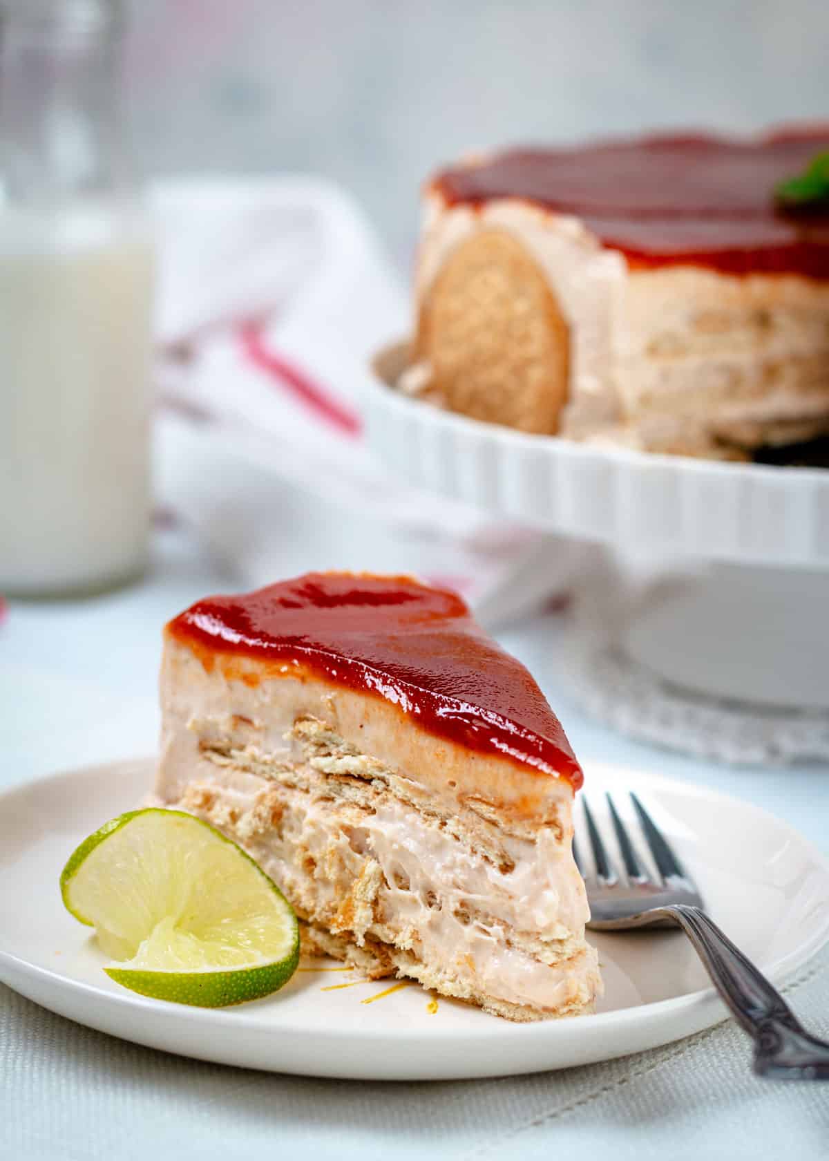 A close up of the Carlota slice on a plate with a fork and lime.